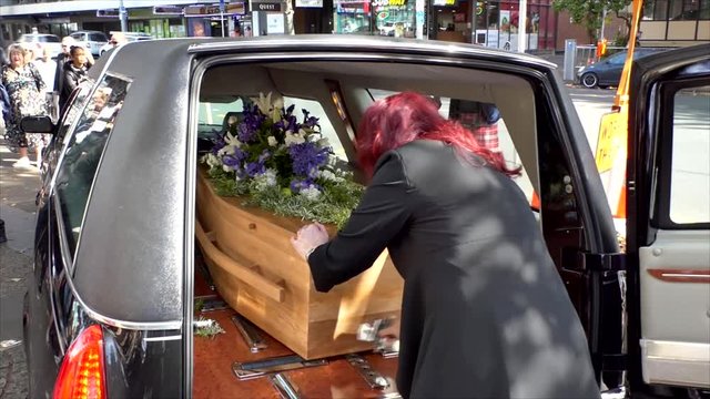 closeup shot of a funeral casket in a hearse or chapel or burial at cemetery