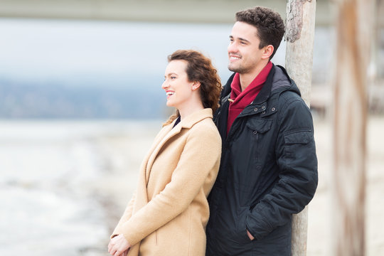 Young couple standing on windy weather outdoors