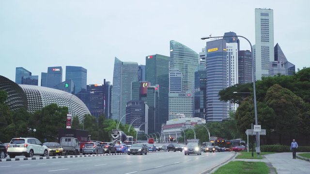 Singapore downtown city skyline with traffic at dusk. The Esplanade Arts Centre with the iconic durian fruit spike like roof architecture sit next to global office in modern towers.