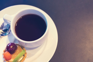 Blurred for Background.Black coffee with Fruit Cake between the brake and the brake food background.