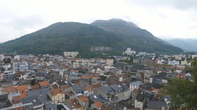 Aerial view of town of Lourdes, France with Pic du Jer peak in the distance. Looking south east. Handheld shot with stabilized camera.