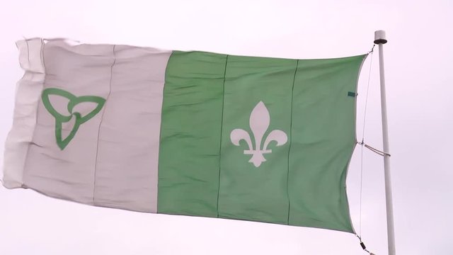 Tilt Up Towards The Franco Ontario Flag, Waving Strong In The Wind.