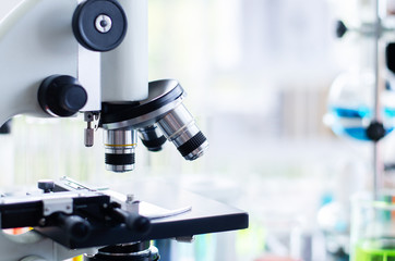 Close-up shot of microscope with metal lens at laboratory. Scientific and healthcare research background.