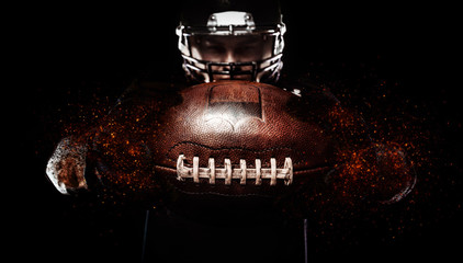 Fototapeta na wymiar American football player, athlete in helmet with ball on black background. Sport wallpaper with copyspace.