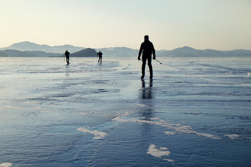 Skaters ride on the ice of Lake Baikal in winter