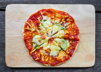 fresh homemade pizza on wooden board, top view