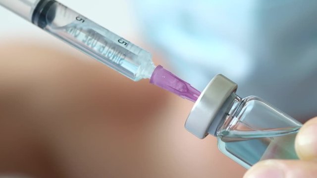 doctor uses a syringe to dispense medication from the bottle. at the hospital. Health and medical concepts