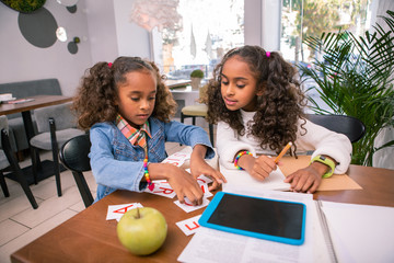 After kindergarten. Two cute beautiful siblings with beautiful curly hair studying together after kindergarten