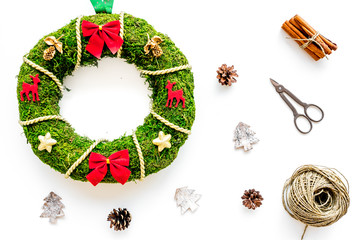 Process of making christmas wreath concept. Green christmas wreath near matherials and instruments, sciccors on white background top view