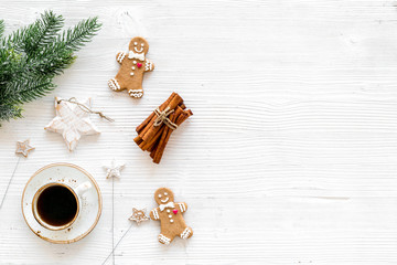 New Year composition with sweets. Gingerbread cookies in shape of man, star near coffee, spruce branch, festive decoration on white background top view copy space