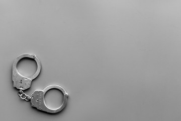 Metal handcuffs on grey background top view space for text