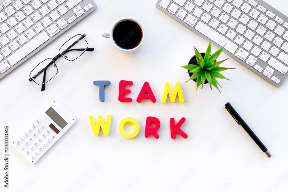 Poster teamwork in office. text teamwork lined with colored letters on white office desk with computer keyb