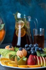 fruit plate. Glass bank of lemonade with sliced citrus fruits on a buffet table