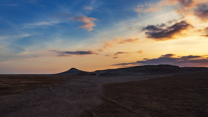 Fototapeta na wymiar Mud volcanoes at sunset, beautiful amazing sky