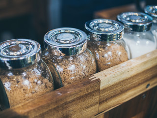 Set of glass bottle of sugar on wooden shelf