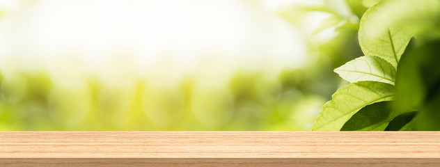 Wood table top and blur natural background in garden for product and display montage banner size