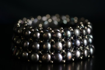Black pearl necklace on a dark background close up