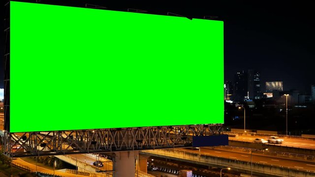 Green screen of advertising billboard on expressway during the twilight with city background in Bangkok, Thailand.