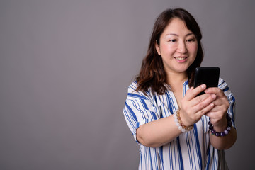 Mature beautiful Asian businesswoman using mobile phone