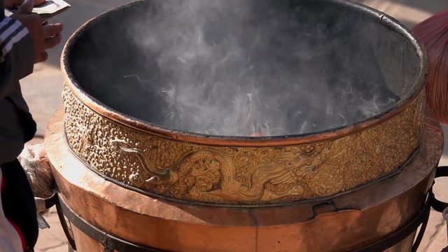 Burning Incense in Cauldron near Buddhist Stupa