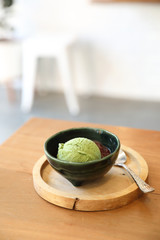 Japanese green tea ice cream with red bean topping on wooden table in coffee shop