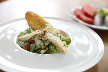 fresh salad with bacon and bread on wooden background