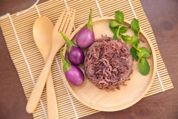 Clean food for healthy,cooked purple rice berry with peppermint leaves and purple eggplant on wooden plate