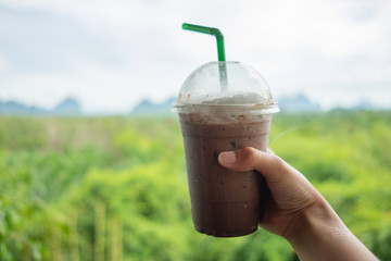 food background hand of woman holding coffee glass with scenery are backdrop