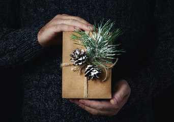 Male hands holding homemade christmas gift dark background Christmas background