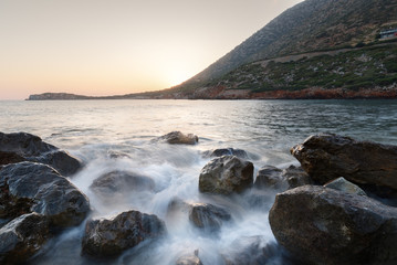 sunsets and sunrises on the rocky coast texture creating amazing patterns and the sea with waves in the background