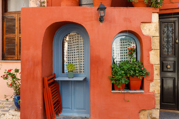 Fototapeta na wymiar national flavor, ancient Greek streets on the island of Crete. Old houses, doors, Windows, potted plants and small outdoor cafes.