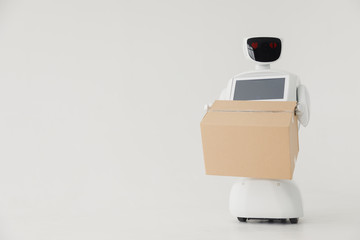Humanoid autonomous robot with cardboard box in hand on white background. the robot delivers the parcel. delivery concept.