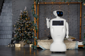 Humanoid autonomous robot on the background of Christmas decorations, Christmas tree, bokeh