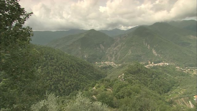 A pan from right to left of the mountains in the countryside of Badalucco, Italy