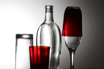 A transparent bottle and red glasses	