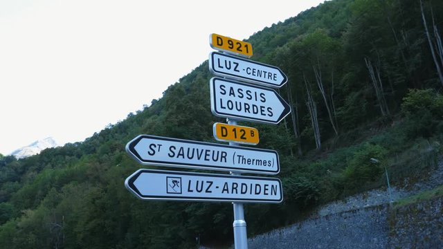 French road sign with directions for Saint Sauveur, Luz-Saint-Sauveur, Sassis, Lourdes and Luz-Ardiden ski area. Pyrenees, France.