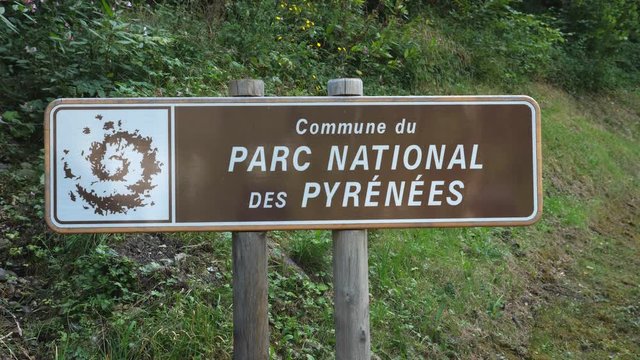 Brown national park sign. Commune du Parc National des Pyrenees, Betpouey, France. Handheld shot with stabilized camera.