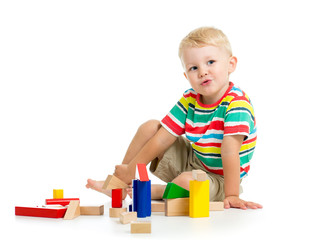 Little boy playing cubes sitting . Isolated on a white background.