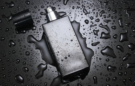 Bottle of men's perfume with water drops on a black background. Fashion concept.