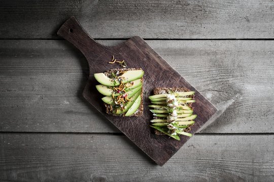 Slices of wholemeal bread topped with avocado and buffalo worms and crickets
