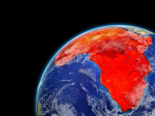 Africa on model of planet Earth with very detailed planet surface and clouds. Continent highlighted in red.