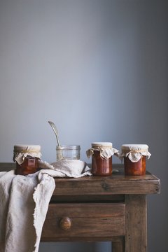 Jars of peach jam on a wooden table