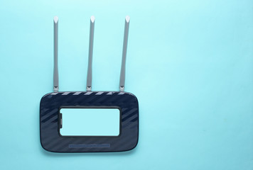 Wi-fi router, smartphone on blue background. Gadgets for modern people. Copy space.