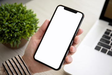 female hands holding touch phone with isolated screen in office