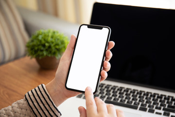female hands holding touch phone with isolated screen in office