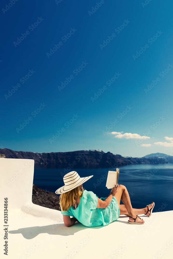 Wall mural Luxury travel vacation woman looking at view on Santorini island