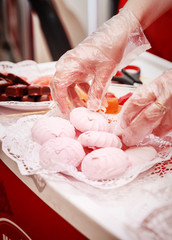 woman lays homemade confectionery on the shop window