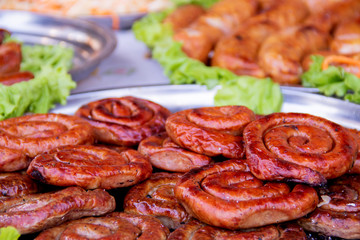 Grilled or Roasted spiral pork sausages with rosemary, salt and peper on plate