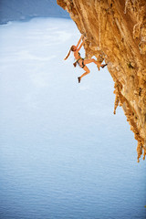 Young female rock climber wearing bikini on cliff
