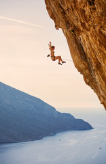 Female rock climber falling of cliff while lead climbing